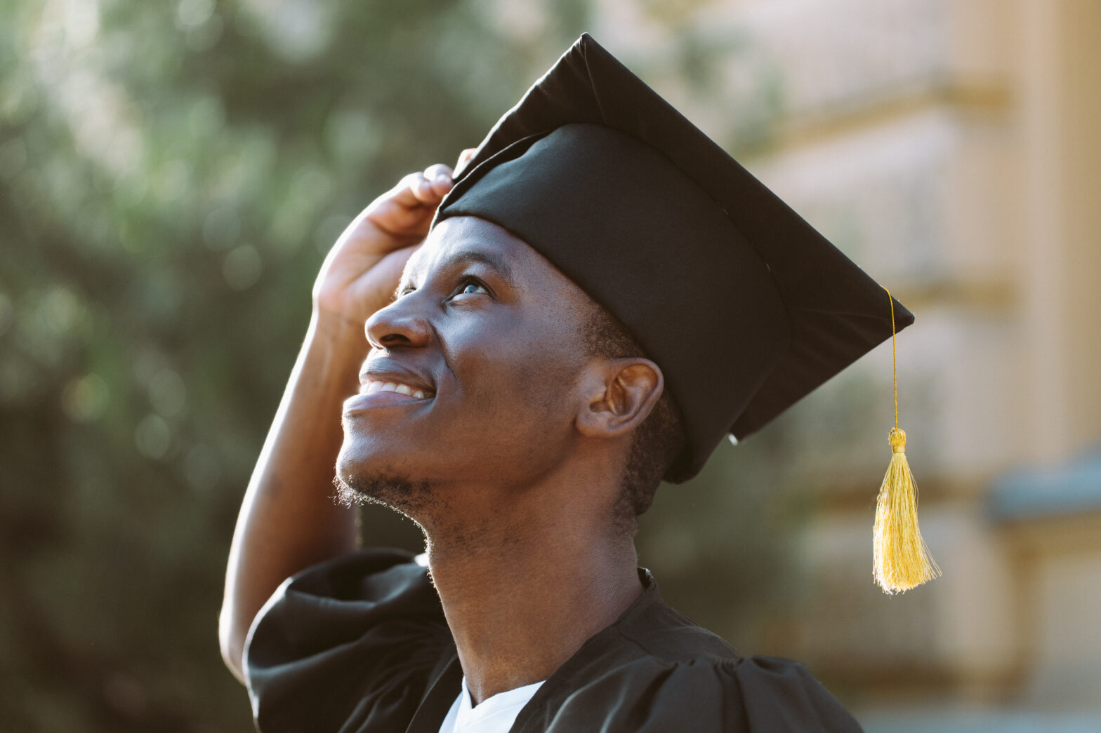 College graduate wearing graduation cap, looking up and at the potential career opportunities ahead of them with The Lee Group